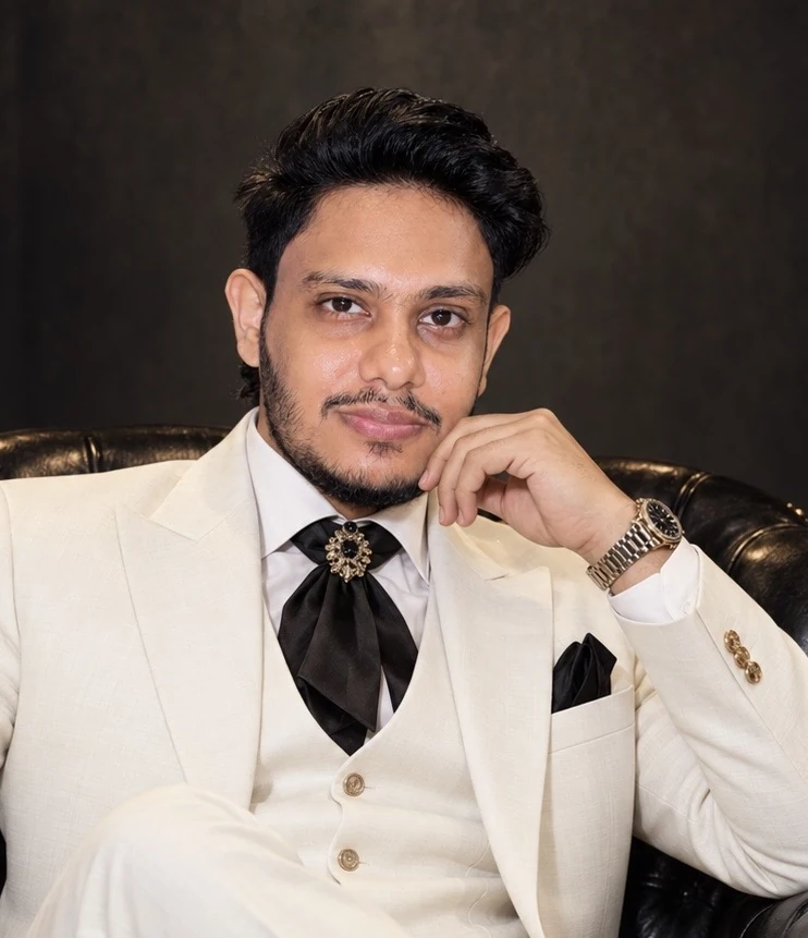 Raza Quadri in an ivory suit, seated for his founder portrait